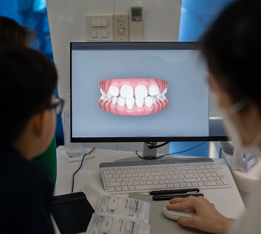 Orthodontist and patient looking at scans of patient's teeth
