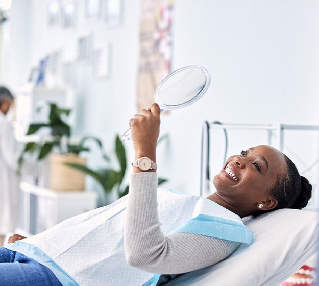Woman smiling while looking at reflection in mirror