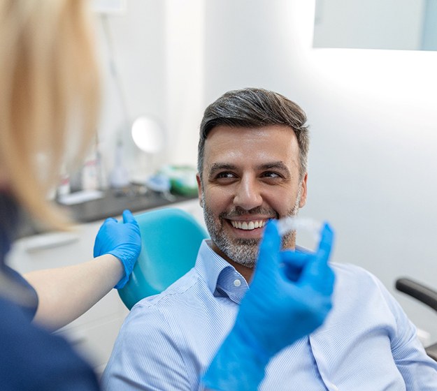 Man smiling in dental chair getting Invisalign