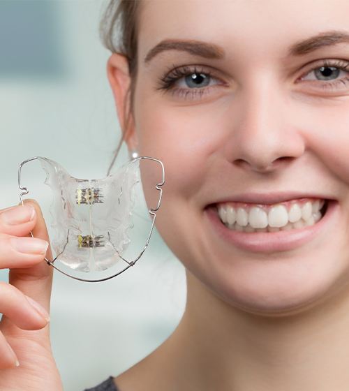 Woman holding retainer orthodontic appliance
