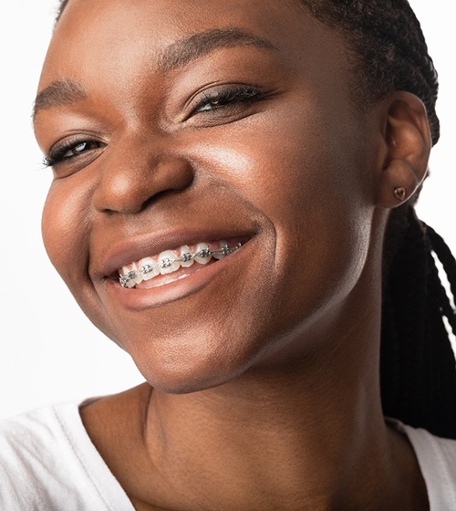 Smiling woman with traditional metal braces in Plano