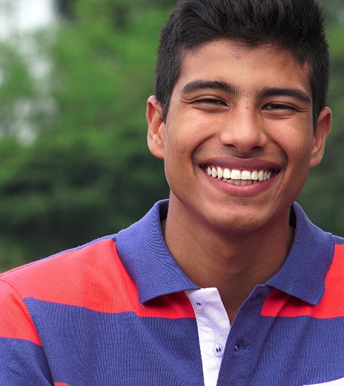 A teenage boy smiling after having his teeth aligned with braces