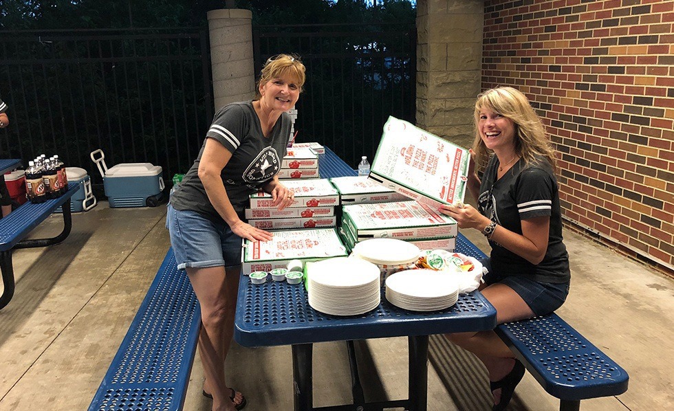 Dental team members serving pizza at community event