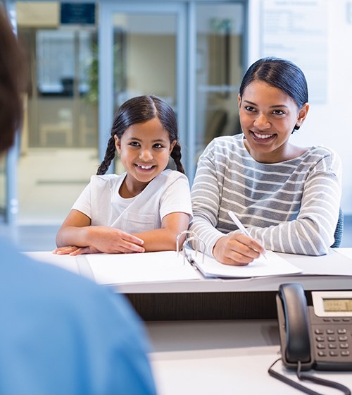 Woman and daughter turning in dental insurance forms