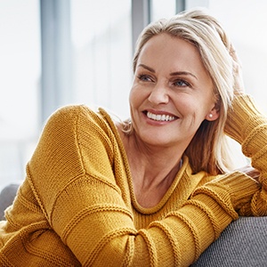 Woman smiling while relaxing on couch at home