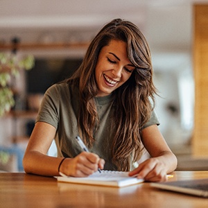 Woman smiling while taking notes