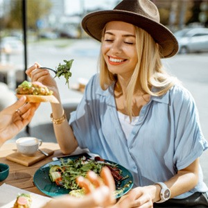 Friends smiling while eating lunch outside