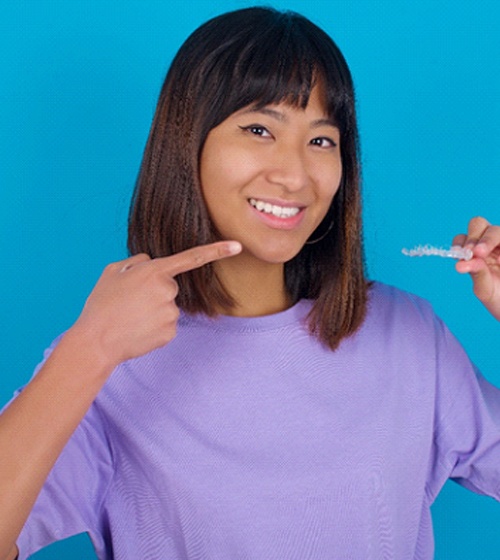 Young girl holding Invisalign in Plano