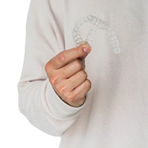 A person holding Invisalign aligners in Plano