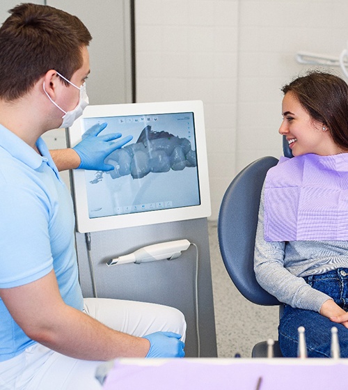 Patient and orthodontic team viewing digital impression of teeth