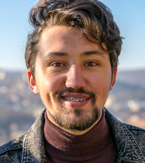 Portrait of smiling man with braces, standing outside