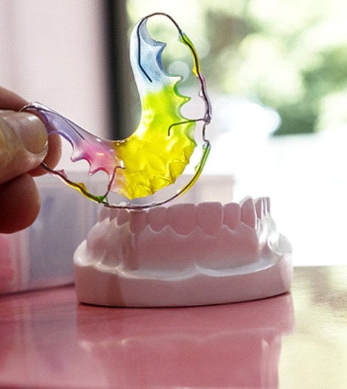 A person holding a Hawley retainer in Plano