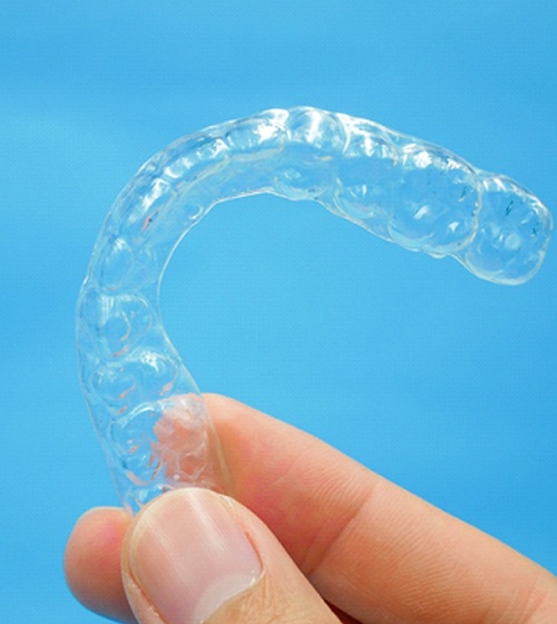 A person holding a plastic coverage retainer in Plano