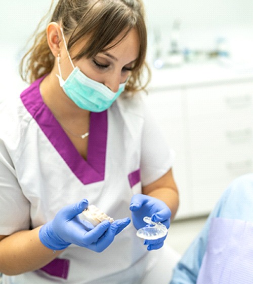 A dentist showing a male patient how a dental splint works in Plano