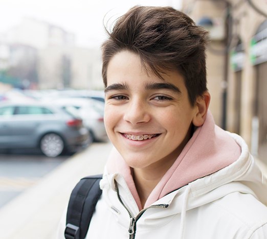 Teen boy with braces, wearing backpack on his shoulder