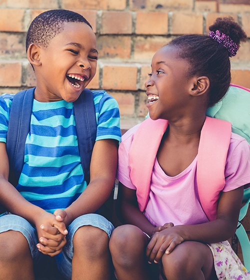 Laughing young boy and girl during phase one pediatric orthodontic treatment