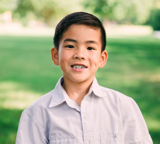 Young boy with orthodontic appliances smiling