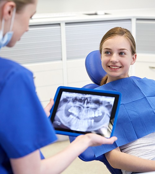 Orthodontist looking at digital x-rays on tablet computer