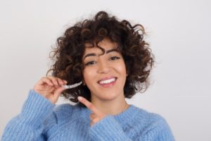 young woman holding clear aligner