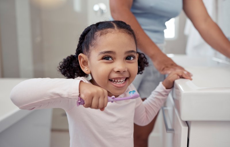 Picture of a smiling child brushing their teeth