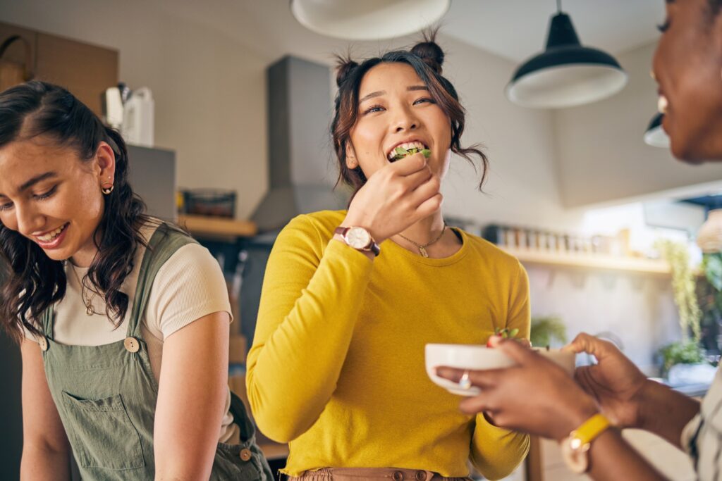 Patient smiling while eating lunch with friends in kitchen