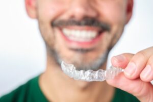Man holding one of his Invisalign trays