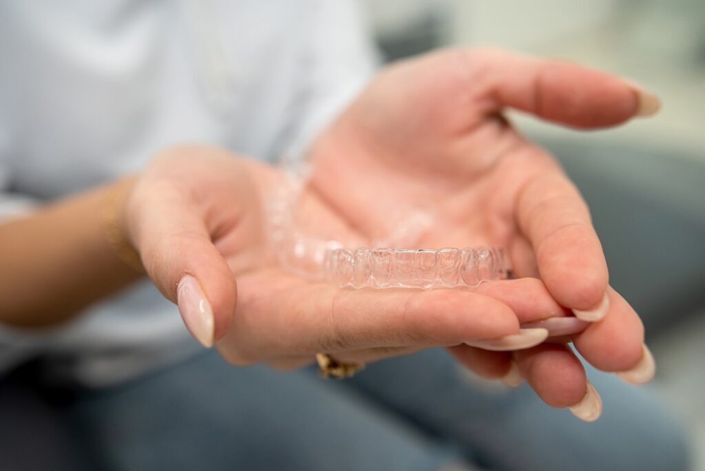 Closeup of patient holding clear aligner